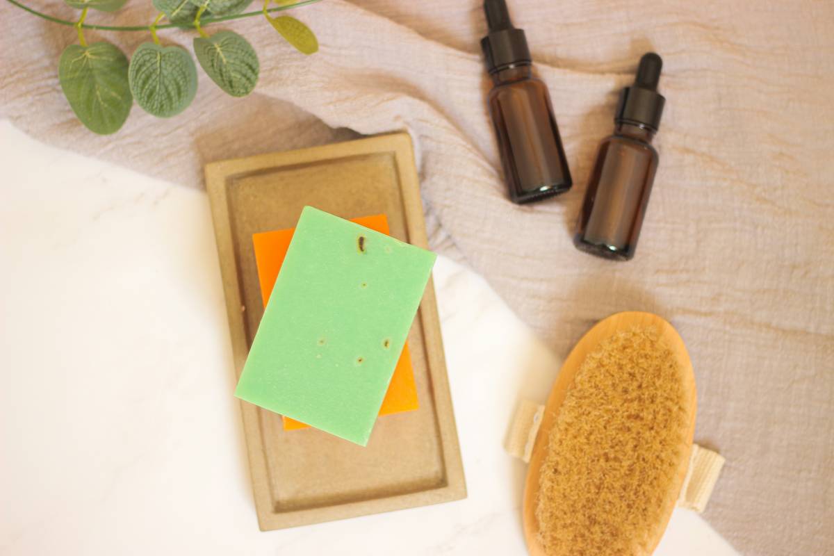 how to body wash person applying gentle lather to forearm with hands, no loofah in sight, soft lighting